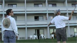 Bruce Richards winds up to launch an XXD through the second story window (there's a fish in the sink). Macauley Lord watches for slack line and stray buffalos